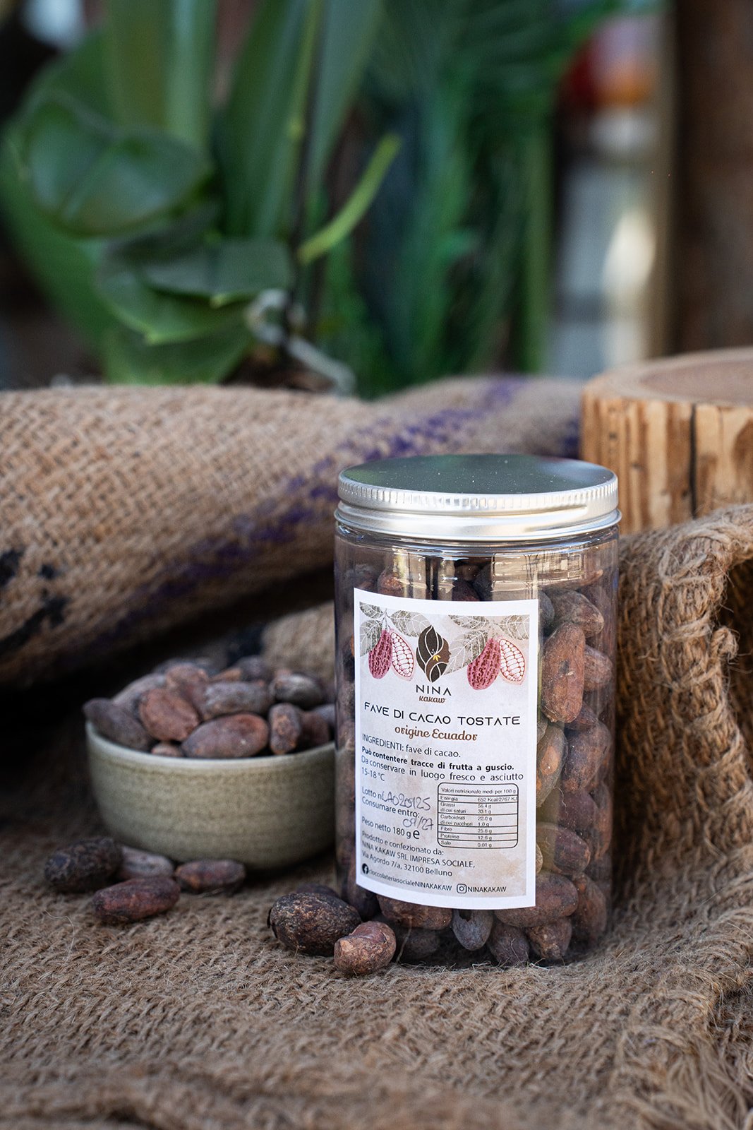 Barattolo di fave di cacao tostate NINA KAKAW origine Ecuador con fave sparse su juta